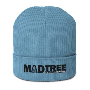 The Organic ribbed beanie is light blue with a folded brim featuring the black MADTREE Foundation logo—a tree graphic inside the letter A and a chain design below the text.