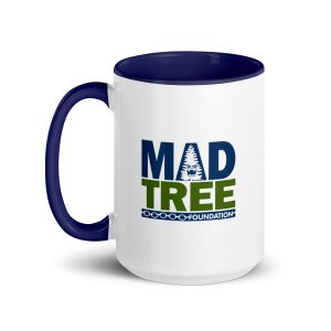 The Mug with Color Inside - Mad Tree is a white ceramic mug with a dark blue handle and interior, displaying the MadTree Foundation logo in blue and green with a stylized tree on the front.