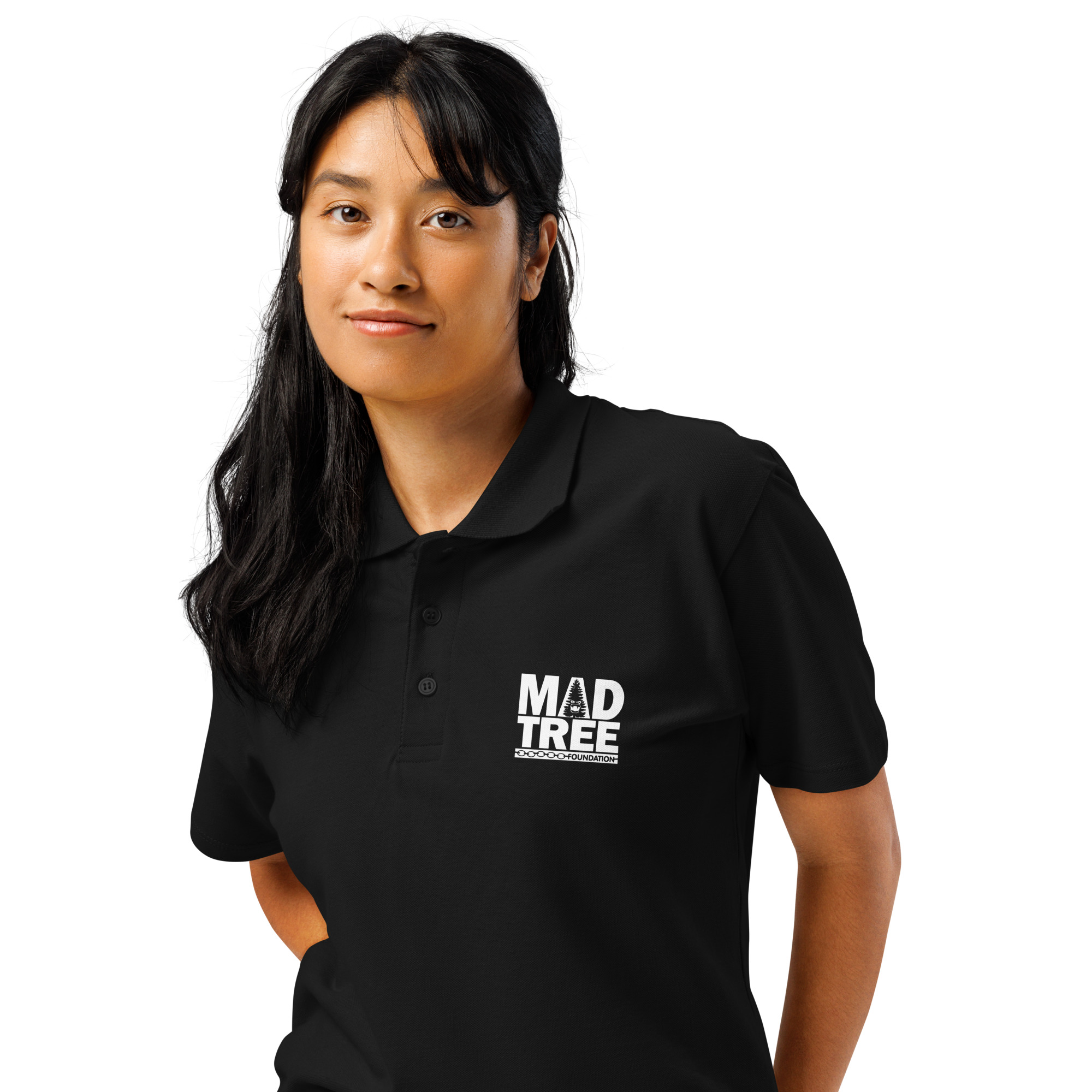 A person with long dark hair wears the Premium pique polo shirt - Mad tree, featuring a MAD TREE logo, standing against a white background and looking at the camera with a slight smile.